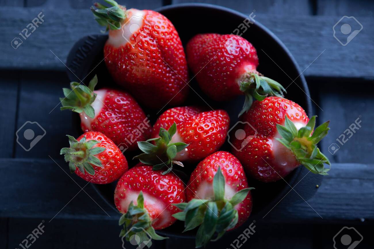 Fresh ripe strawberries on a black wooden background. - 151402324 Fresh ripe strawberries on a black wooden background. - 151402324