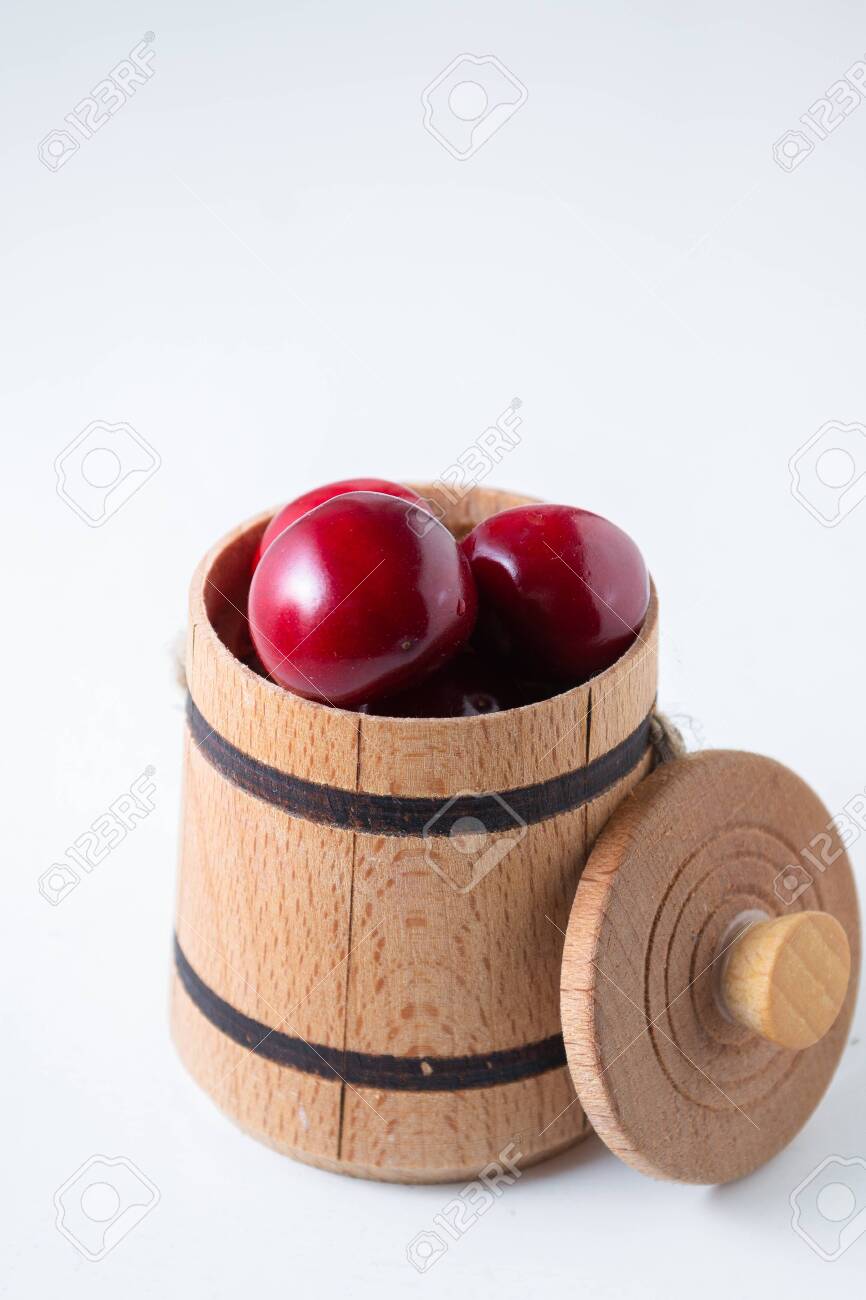 Sweet cherry berries in a wooden small barrel on a white background isolate. - 151404140 Sweet cherry berries in a wooden small barrel on a white background isolate. - 151404140