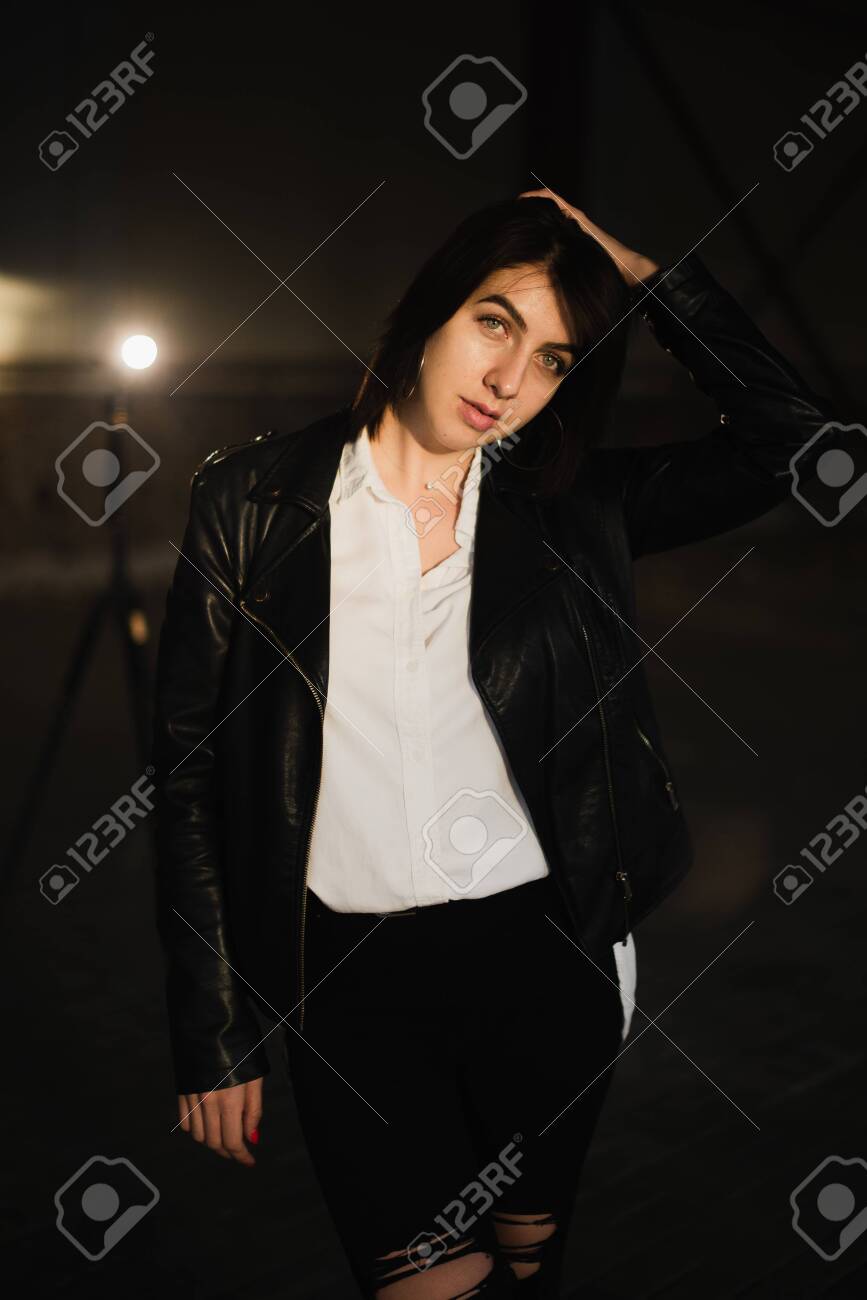 Girl in a leather jacket on an old abandoned construction site. - 155052683 Girl in a leather jacket on an old abandoned construction site. - 155052683