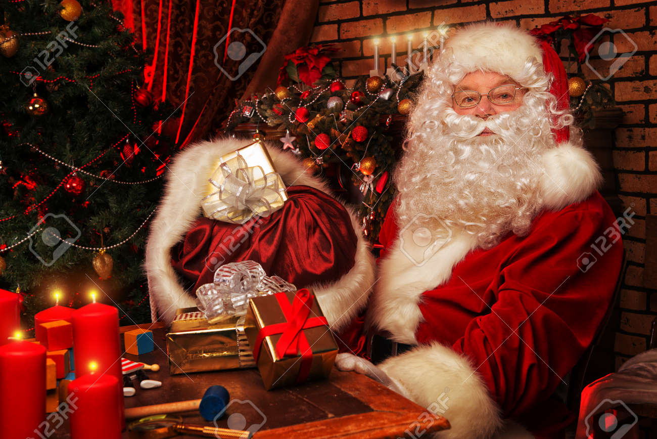 Santa Claus Making Christmas Gifts At Home Stock Photo