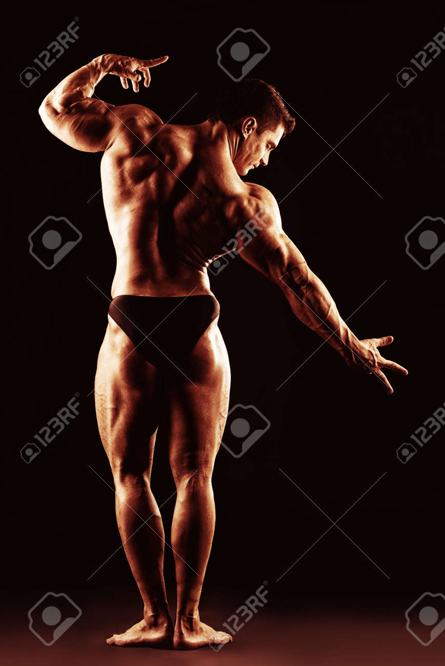 暗い背景上に戻ってポーズ美しい筋肉男ボディービルダー の写真素材 画像素材 Image