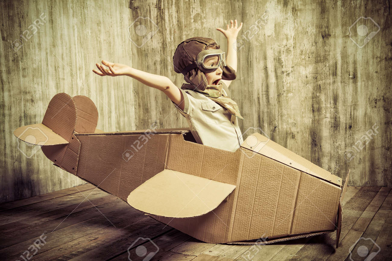 ダンボール飛行機で遊ぶかわいい夢想家の少年 小児 ファンタジー 想像力 レトロなスタイル の写真素材 画像素材 Image