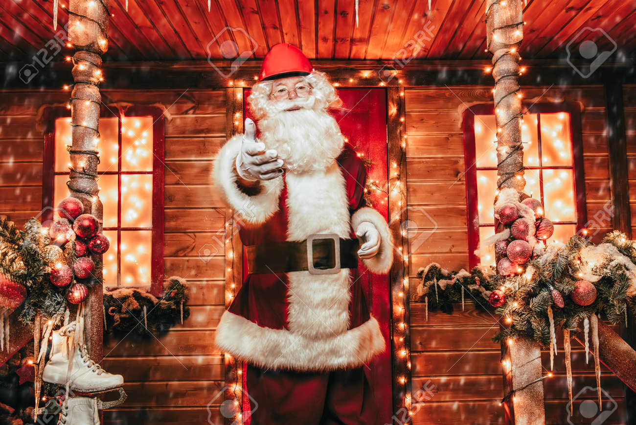 Santa Claus Casa Di Babbo Natale.Immagini Stock Babbo Natale E Un Costruttore Casa Di Babbo Natale Il Ritratto Di Santa Claus In Un Casco Sulla Sua Testa Che Sta Vicino Alla Sua Casa Decorata E Mostra