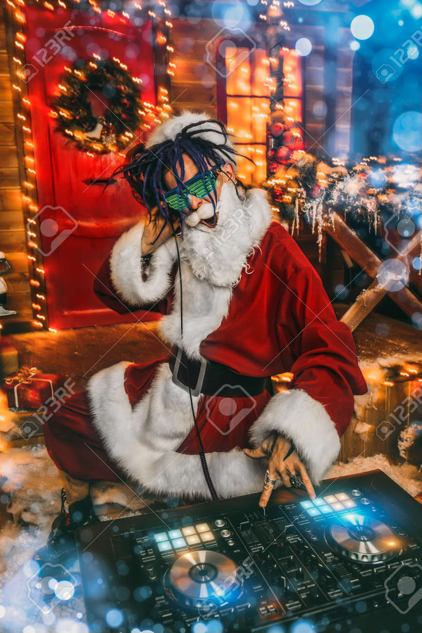 Immagini Natalizie Occhiali.Immagini Stock Babbo Natale Punk In Occhiali Luminosi E Cuffie Tiene Una Festa Vicino Alla Sua Casa Decorata Con Luci Festa Natalizia Image 92295239