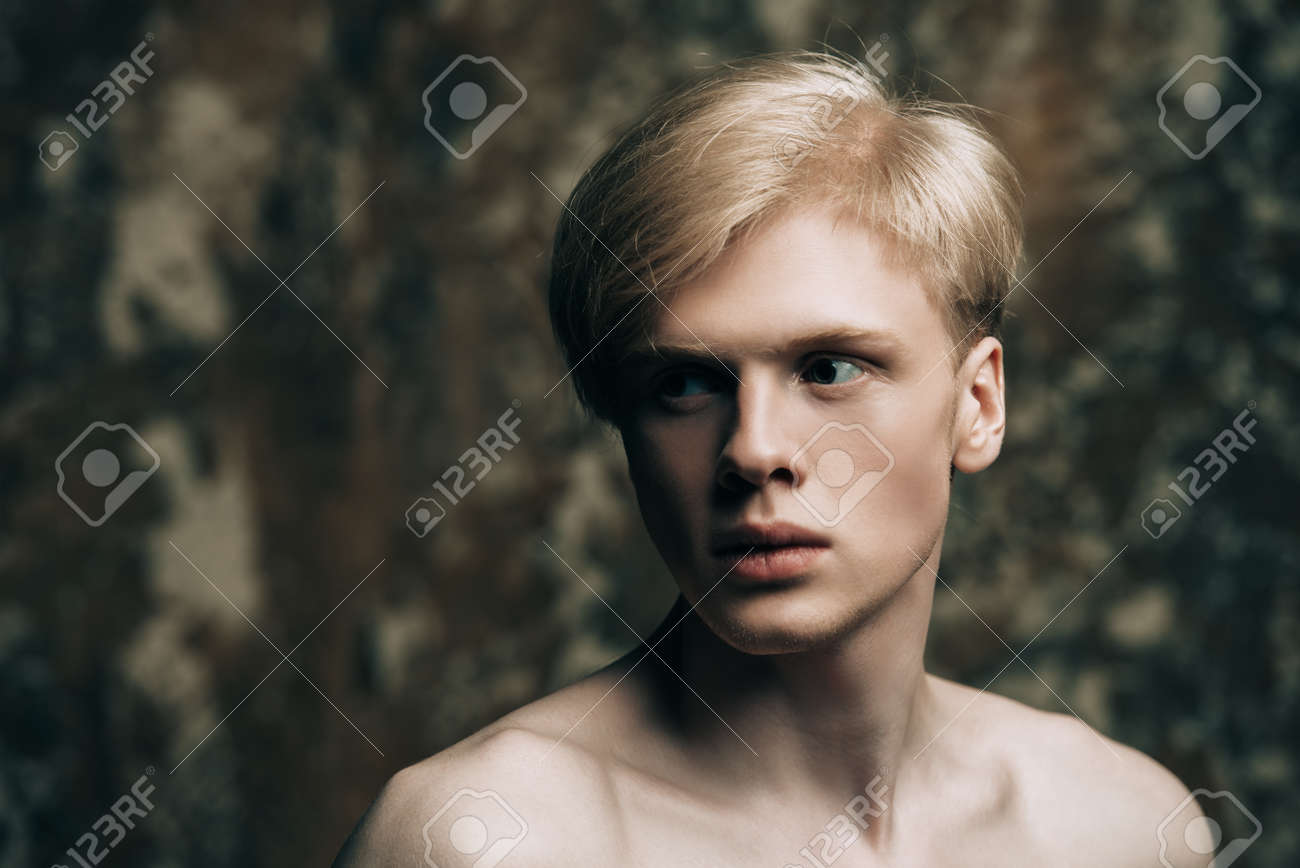 Portrait Of A Shirtless Young Man With Blond Hair Posing At Studio