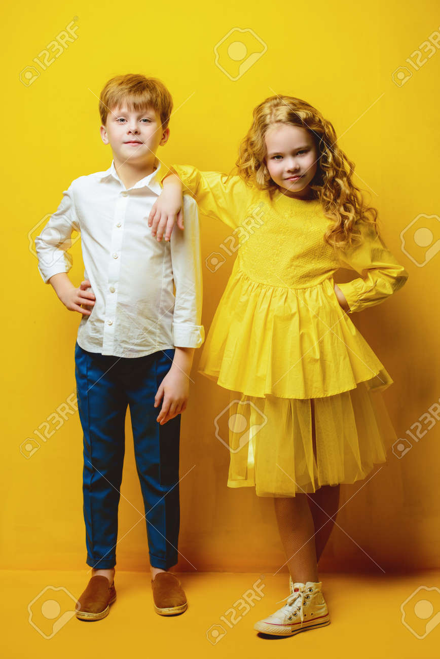 Children's Fashion. Beautiful Boy And Girl In Elegant Clothes Posing  Together At Studio Over Yellow Background. Full Length Portrait. Stock  Photo, Picture and Royalty Free Image. Image 111518653., image size:868x1300