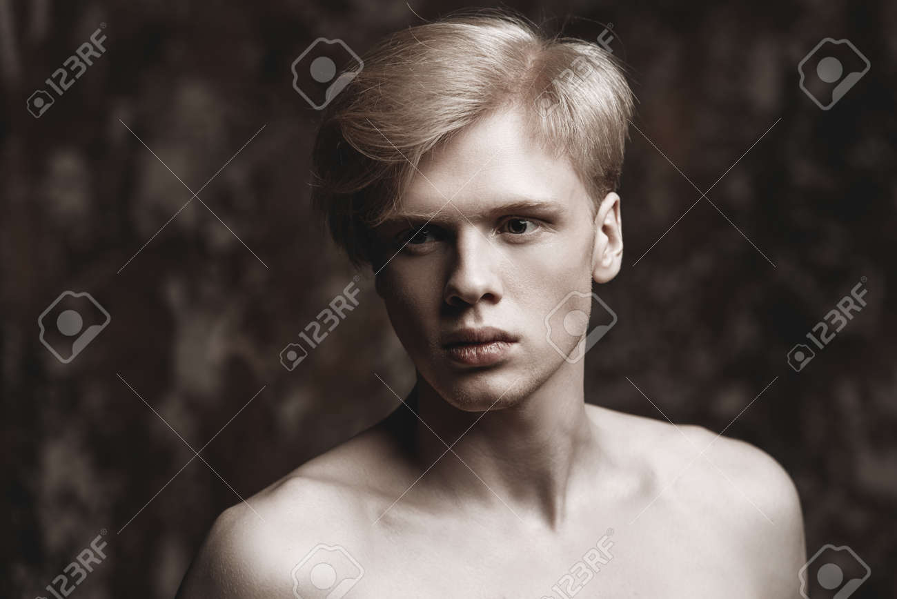 Portrait Of A Shirtless Young Man With Blond Hair Posing At Studio