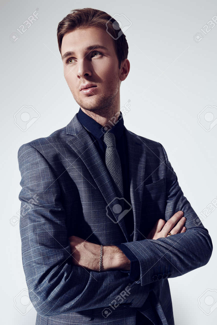 A portrait of a handsome young businessman in a formal suit at studio. Men's fashion. - 135950597 A portrait of a handsome young businessman in a formal suit at studio. Men's fashion. - 135950597