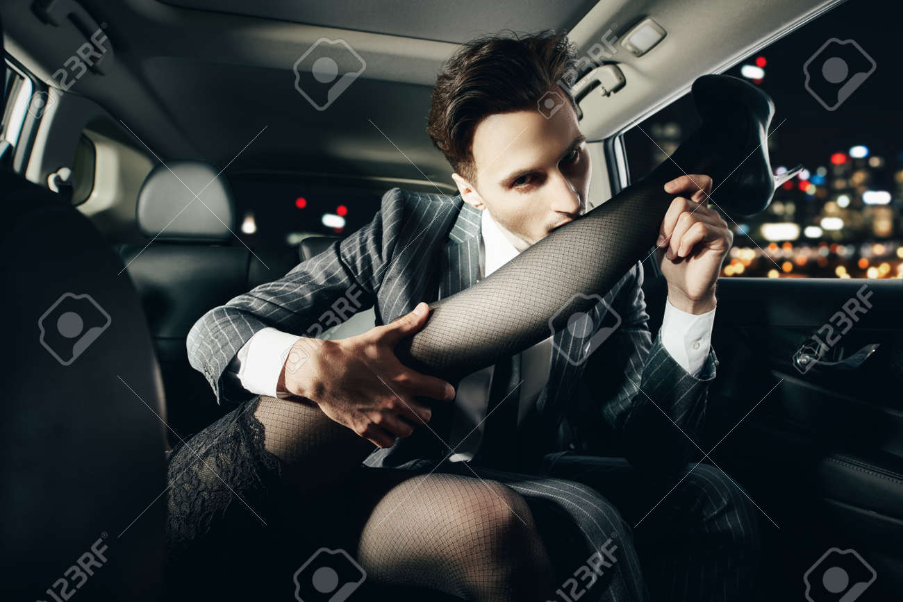 車の中でガールフレンドの足を熱心に噛んでいる男がガールフレンドとイチャイチャ。愛と情熱。の写真素材・画像素材 Image 155659374