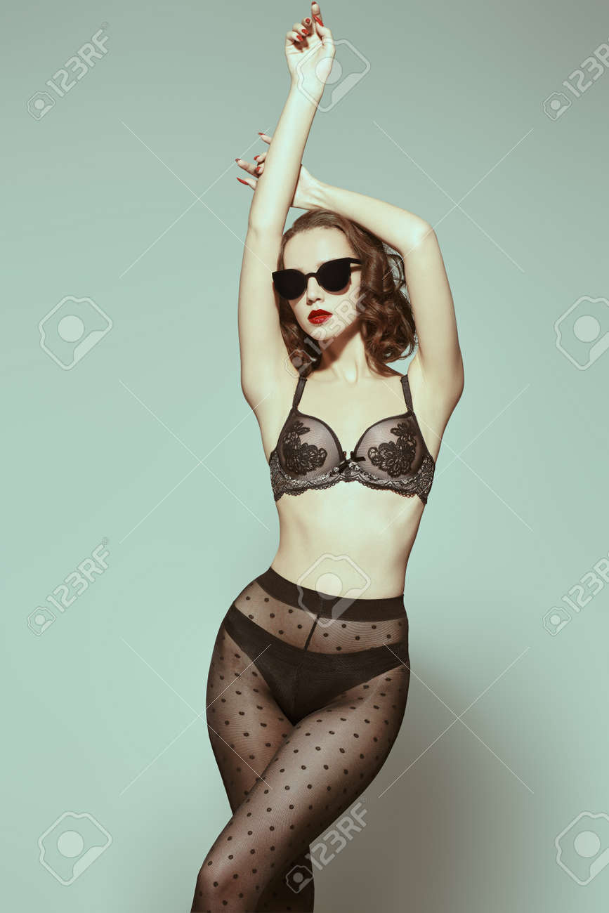 Sexual Babe In Sunglasses And Black Sexy Lingerie And Fishnet Tights Poses  At Studio. Portrait On A Light Blue-gray Background. Фотография, картинки,  изображения и сток-фотография без роялти. Image 167310370