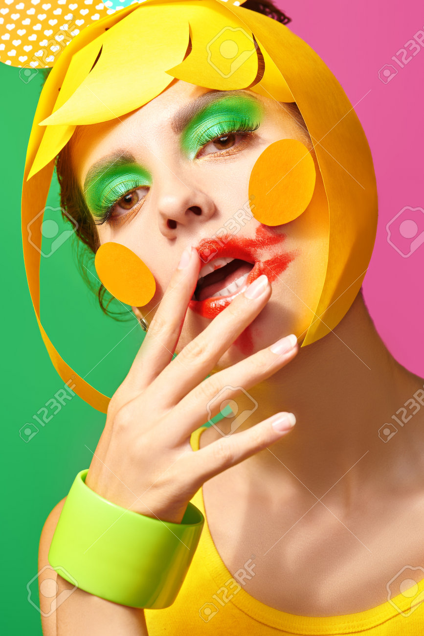 Bright make-up and cosmetics. Close up portrait of a fashionable beauty girl with colorful paper makeup and hairstyle and smudged lipstick on green and fuchsia background. - 167921437 Bright make-up and cosmetics. Close up portrait of a fashionable beauty girl with colorful paper makeup and hairstyle and smudged lipstick on green and fuchsia background. - 167921437
