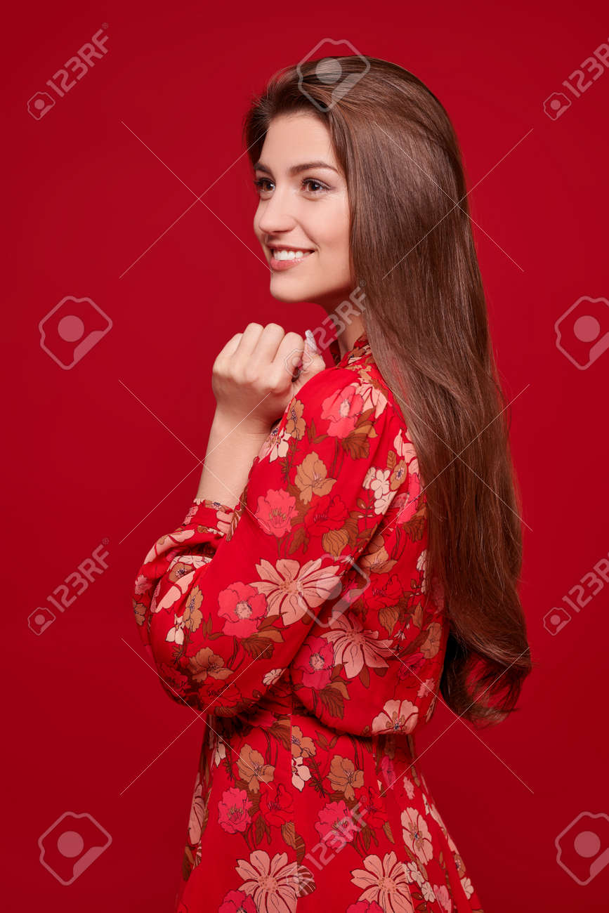 Charming happy girl in bright summer dress on a red background. Love and Valentine's Day. - 167921352 Charming happy girl in bright summer dress on a red background. Love and Valentine's Day. - 167921352
