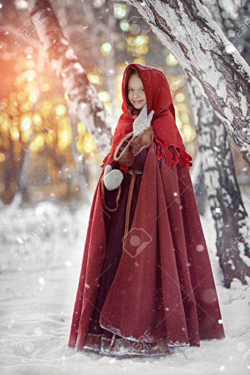 Old Christmas Tale. Cute Medieval Girl In Winter Clothes With A Cape And A  Hood Walks Through The Snowy Forest Joyfully Smiling. Historical  Reconstruction. Full Length Shot. Stock Photo, Picture and Royalty, image size:867x1300