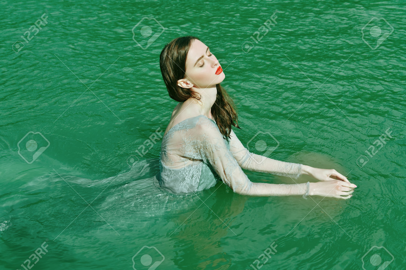 Water Nymph. A Tender Beautiful Girl With Dark Hair In A Light Flowing  Dress Poses In The Water Of The Lake. Fairytale Heroine. Фотография,  картинки, изображения и сток-фотография без роялти. Image 192583342