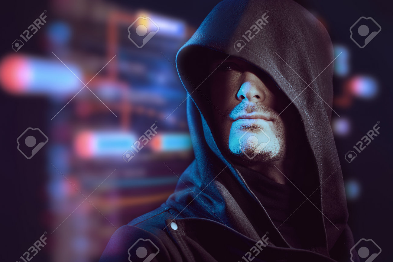 디지털 홀로그램을 배경으로 머리에 후드가 달린 검은 가운을 입고 자신감 있는 표정을 지닌 집중된 남자의 초상화. 사이버 테마. 비트코인,  암호화폐. 복사 공간. 로열티 무료 사진, 그림, 이미지 그리고 스톡포토그래피. Image 199378981