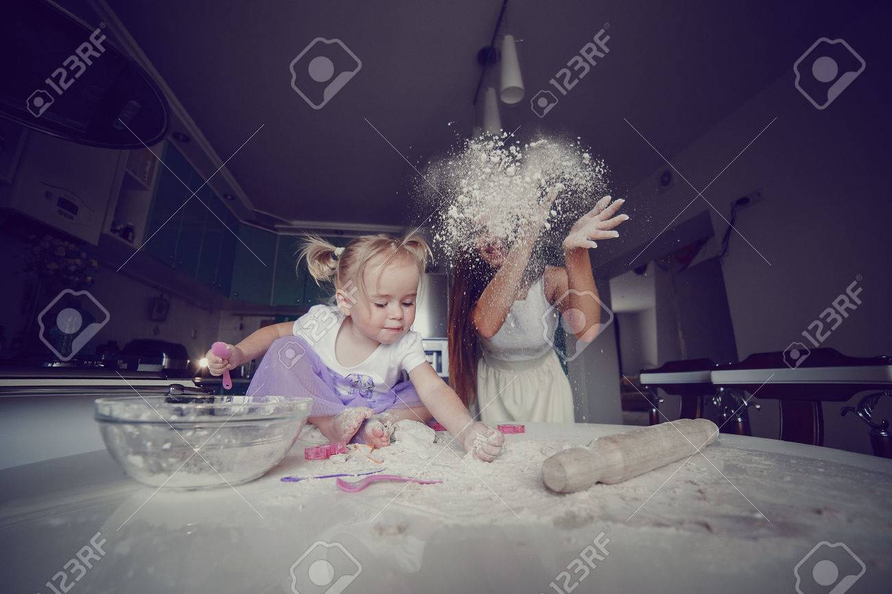 young beautiful mother teaches daughter prepare dough in the kitchen - 42926018 young beautiful mother teaches daughter prepare dough in the kitchen - 42926018