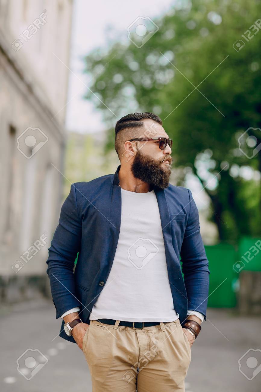 スタイリッシュな服を着て男らしいのひげを生やした男が通りの上に立つ の写真素材 画像素材 Image