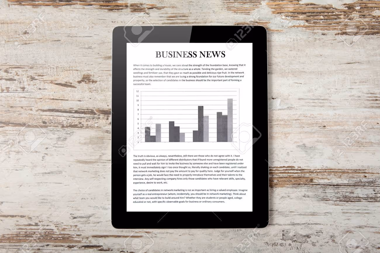 Tablet computer with business news on a screen on a background of wood - 17205410 Tablet computer with business news on a screen on a background of wood - 17205410