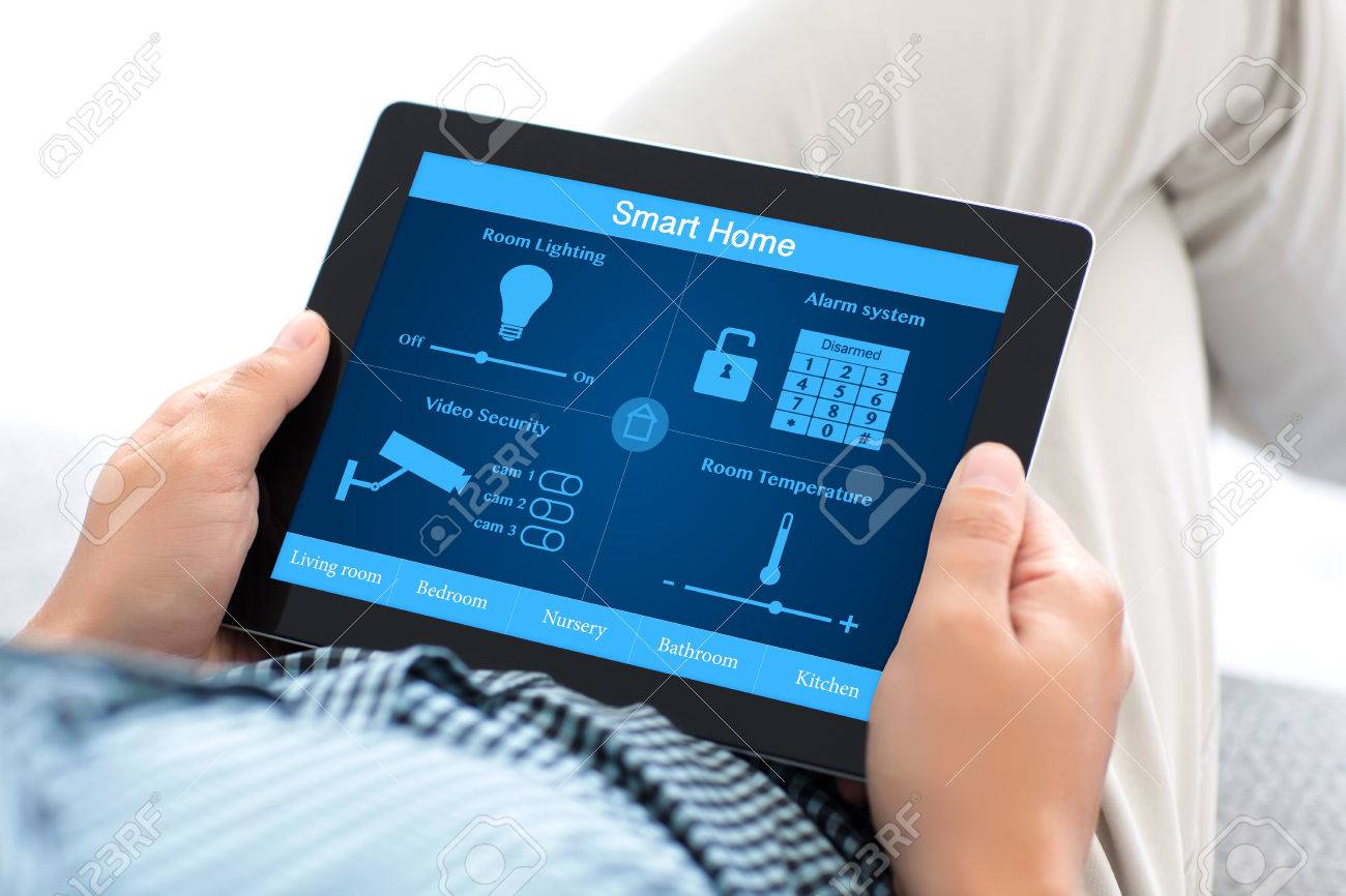 man sitting on a sofa and holding a tablet computer with smart home on the screen Stock Photo - 53553969 man sitting on a sofa and holding a tablet computer with smart home on the screen Stock Photo - 53553969