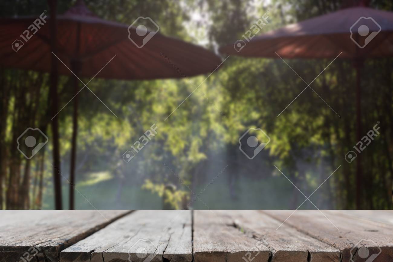 Mesa De Madeira Para Montagem Ou Exibir Seu Produto Com Fundo De Guarda Chuva Vermelho No Patio Com Raio De Luz Atraves Da Arvore De Bambu No Jardim Fotos Retratos Imagenes Y Fotografia