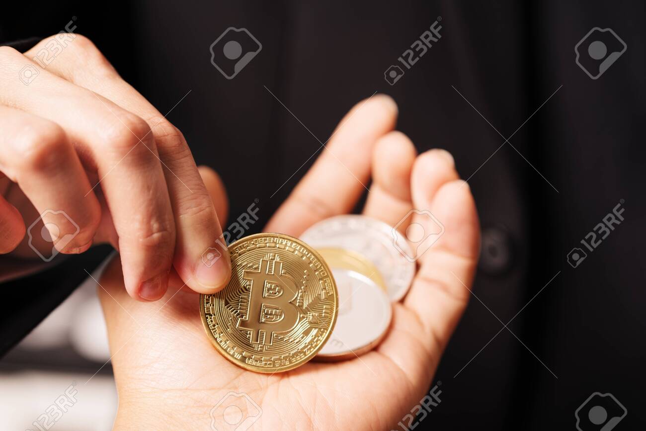 암호화폐 비트코인. 여성들은 암호화폐 코인을 손에 들고 있습니다. 실물 비트코인 금화 로열티 무료 사진, 그림, 이미지 그리고  스톡포토그래피. Image 128414710