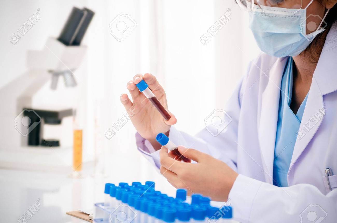 close up of scientist holding and examining blood sample in lab - 41452362 close up of scientist holding and examining blood sample in lab - 41452362