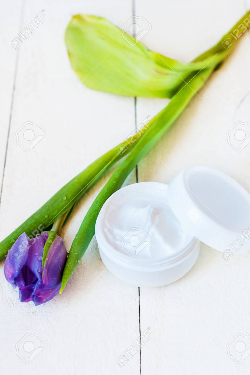 チューリップと白い木製のテーブルの上の銘刻文字のない白い瓶に顔クリームは 淡水の水滴します の写真素材 画像素材 Image