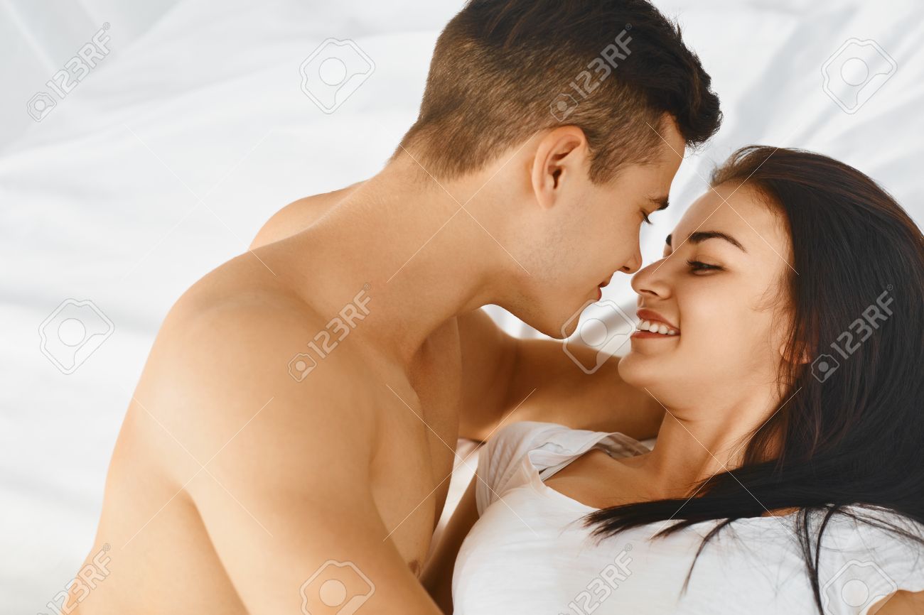close up portrait of a young romantic couple hugging and kissing