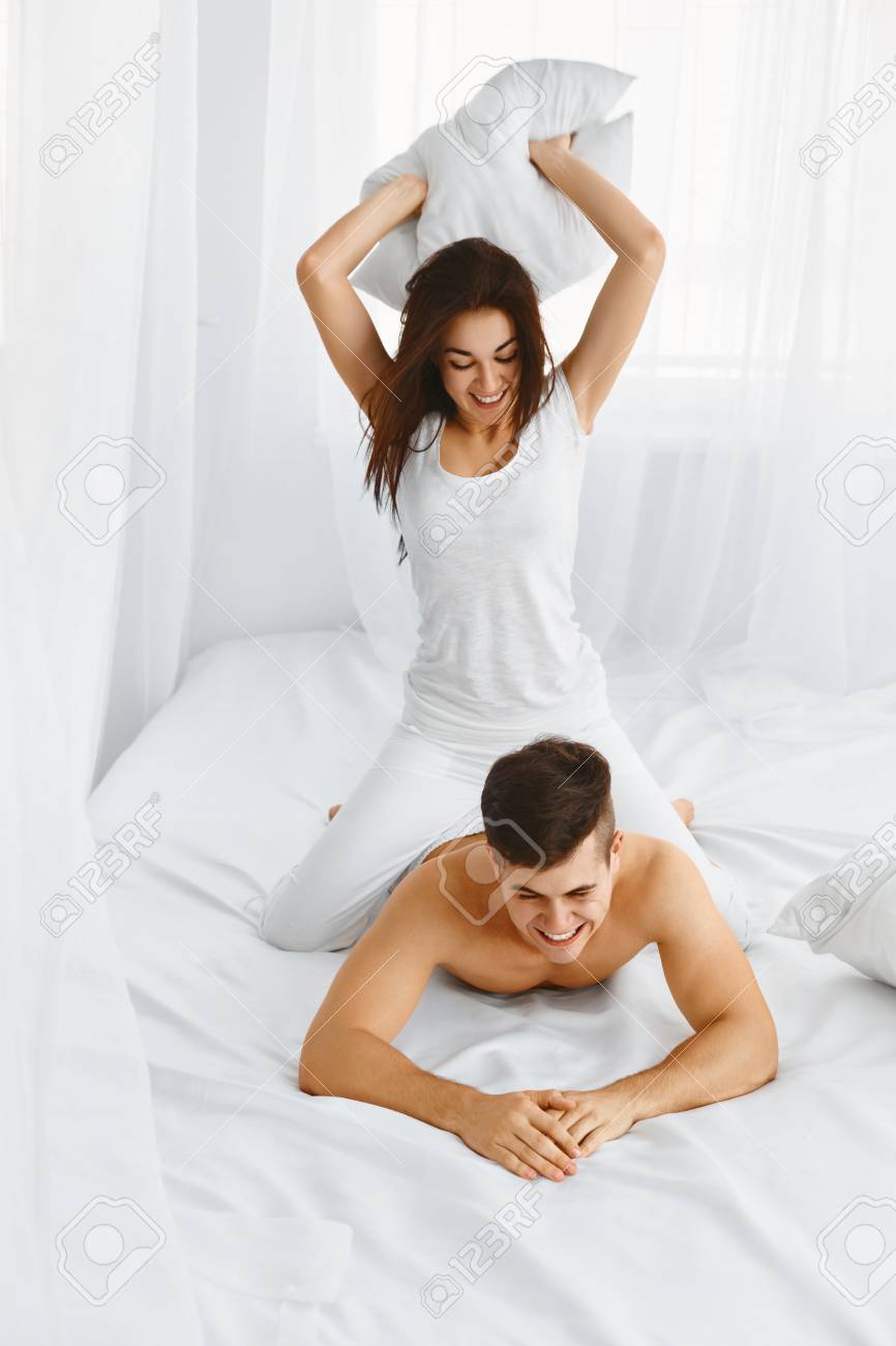 Young Beautiful Couple Having Fun On The Bed In The Bedroom In