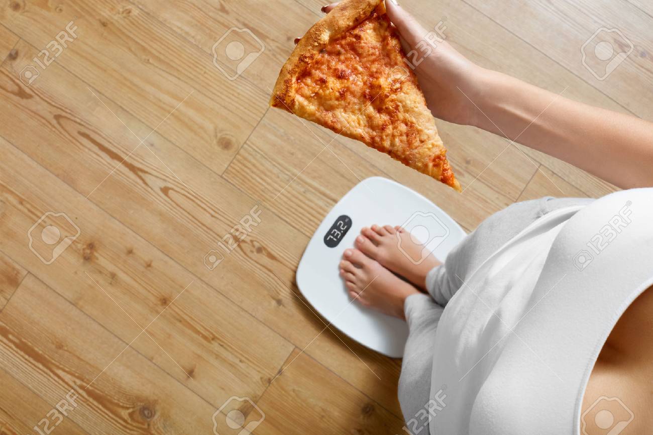 diet and fast food concept overweight woman standing on weighing