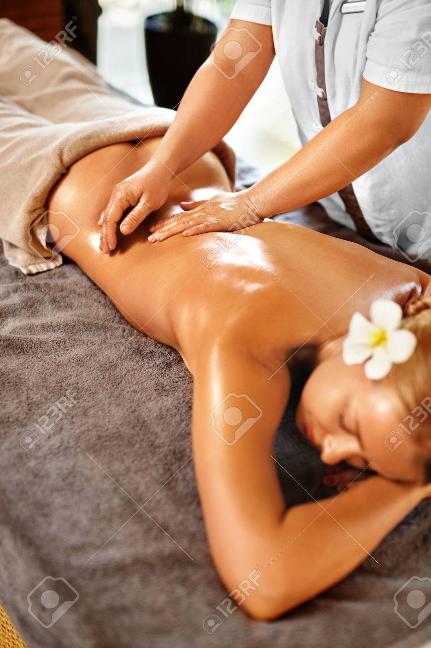 Spa Woman. Beauty Treatment. Close-up Of Sexy Healthy Girl Enjoying  Relaxing Hand Massage Procedure In Cosmetology Spa Centre, Salon. Masseur  Massaging Female Back With Oil. Body, Skin Care Therapy Stock Photo, Picture
