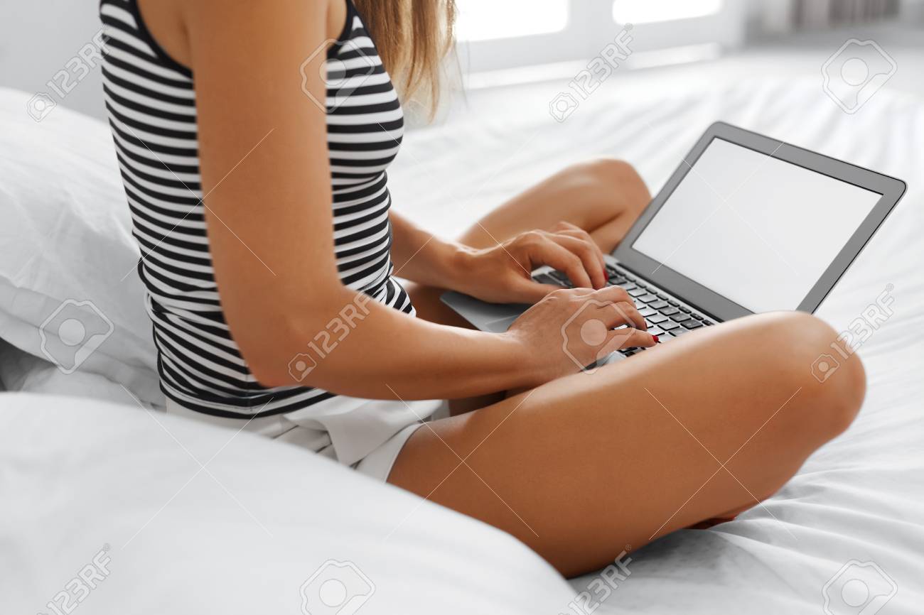 通信技術 フリーランサーの女性がベッドの上に座ってノート パソコンを使用してのポートレート クローズ アップ 女性が働いて 家でノートのキーボードで入力します インターネット オンライン ショッピング概念 の写真素材 画像素材 Image