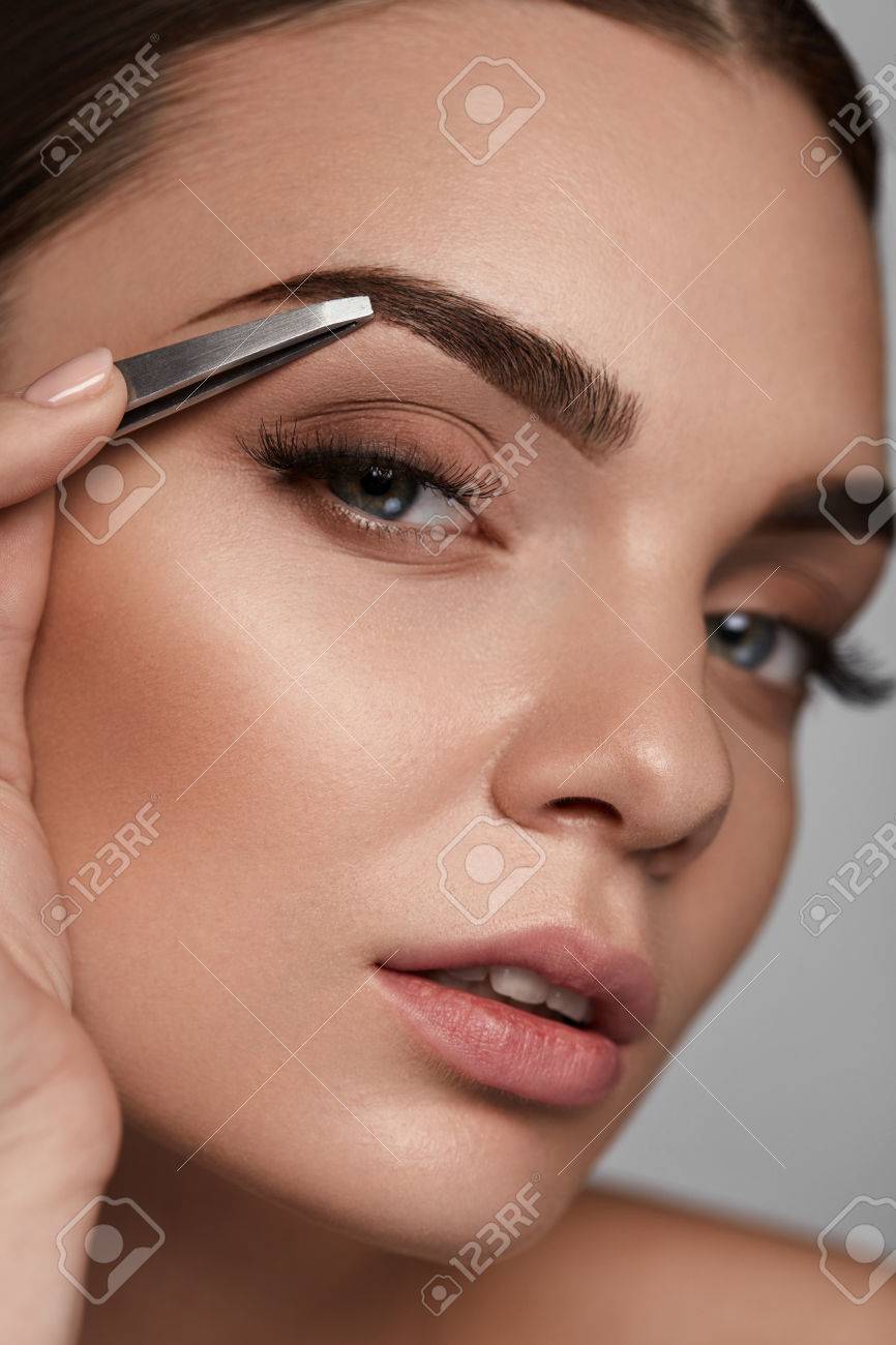 Corrección De Cejas Detalle De La Hermosa Mujer Joven Con Maquillaje Perfecto Y Largas Pestañas Depilarse Las Cejas Retrato De La Hembra Atractiva De La Cara Del Modelo Y Pinzas Cerca De