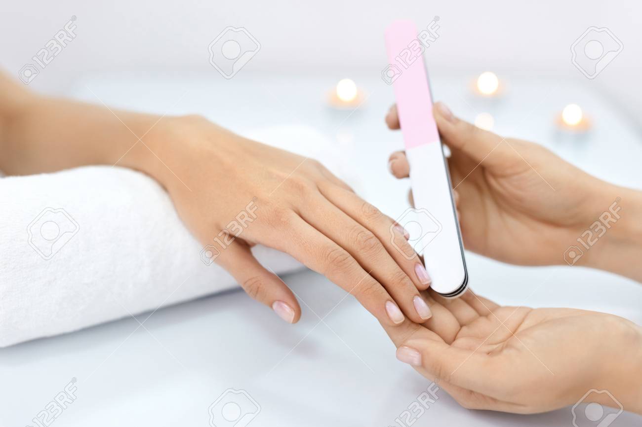 ネイルケアします 女性の手は美しさのネイルサロンでプロの爪やすりで爪をファイリングのクローズ アップ 女性の手に完璧なマニキュアをしている美容師の手のクローズ アップ 爪の衛生 高分解能 の写真素材 画像素材 Image
