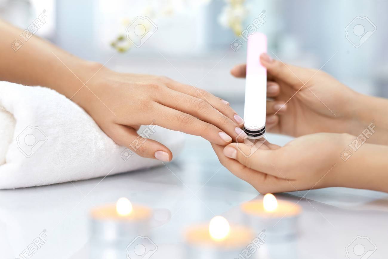 ネイルケアします 女性の手は美しさのネイルサロンでプロの爪やすりで爪をファイリングのクローズ アップ 女性の手に完璧なマニキュアをしている美容師の手のクローズ アップ 爪の衛生 高分解能 の写真素材 画像素材 Image