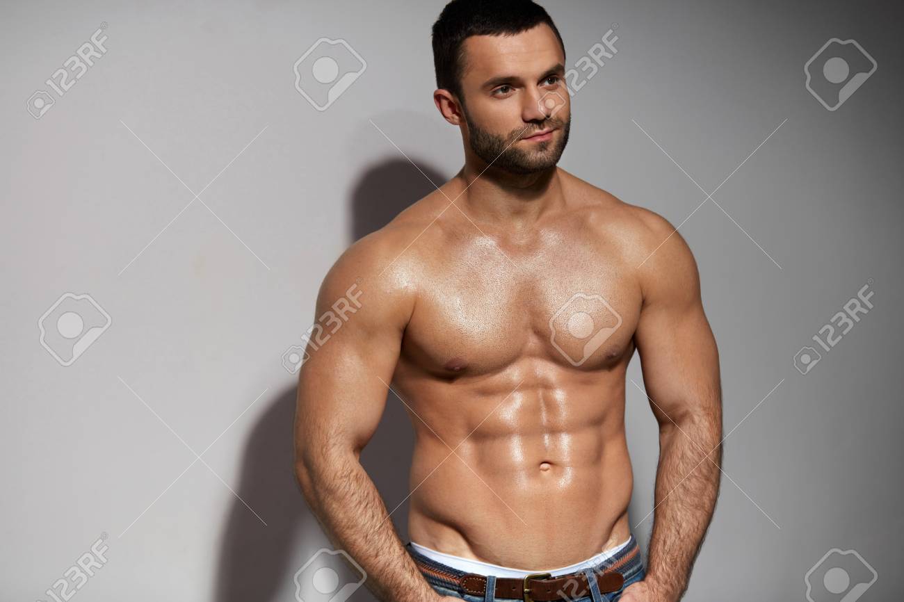 Male Fitness Model With Sexy Muscular Body Portrait. Handsome Hot Young Man  With Fit Athletic Body Shape, Perfect Abs Muscles And Naked Torso On Grey  Background. Bodybuilding Concept. High Resolution Фотография, картинки,