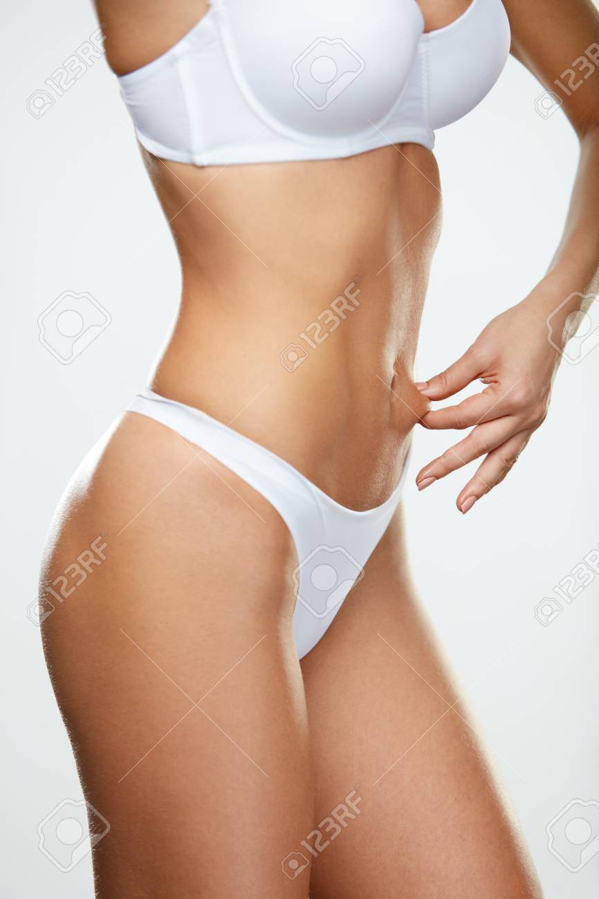 セクシーなボディ形状 腹皮をつまんで白い下着で美しいスリムな女性ボディのクローズ アップ 肌測定脂肪の胃を保持している完璧な図とホット フィット女性 ダイエットのコンセプトです 高分解能 の写真素材 画像素材 Image
