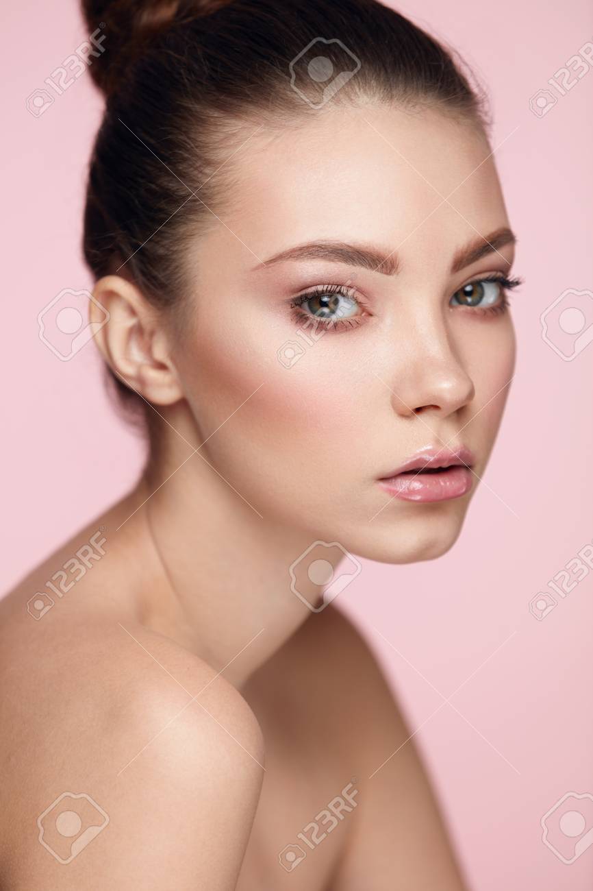 Beauty Woman Face. Closeup Of Beautiful Young Female Model With Soft Smooth  Skin And Professional Natural Facial Makeup. Portrait Of Sexy Girl With  Perfect Make-up On Pink Background. High Resolution Stock Photo,, image size:866x1300