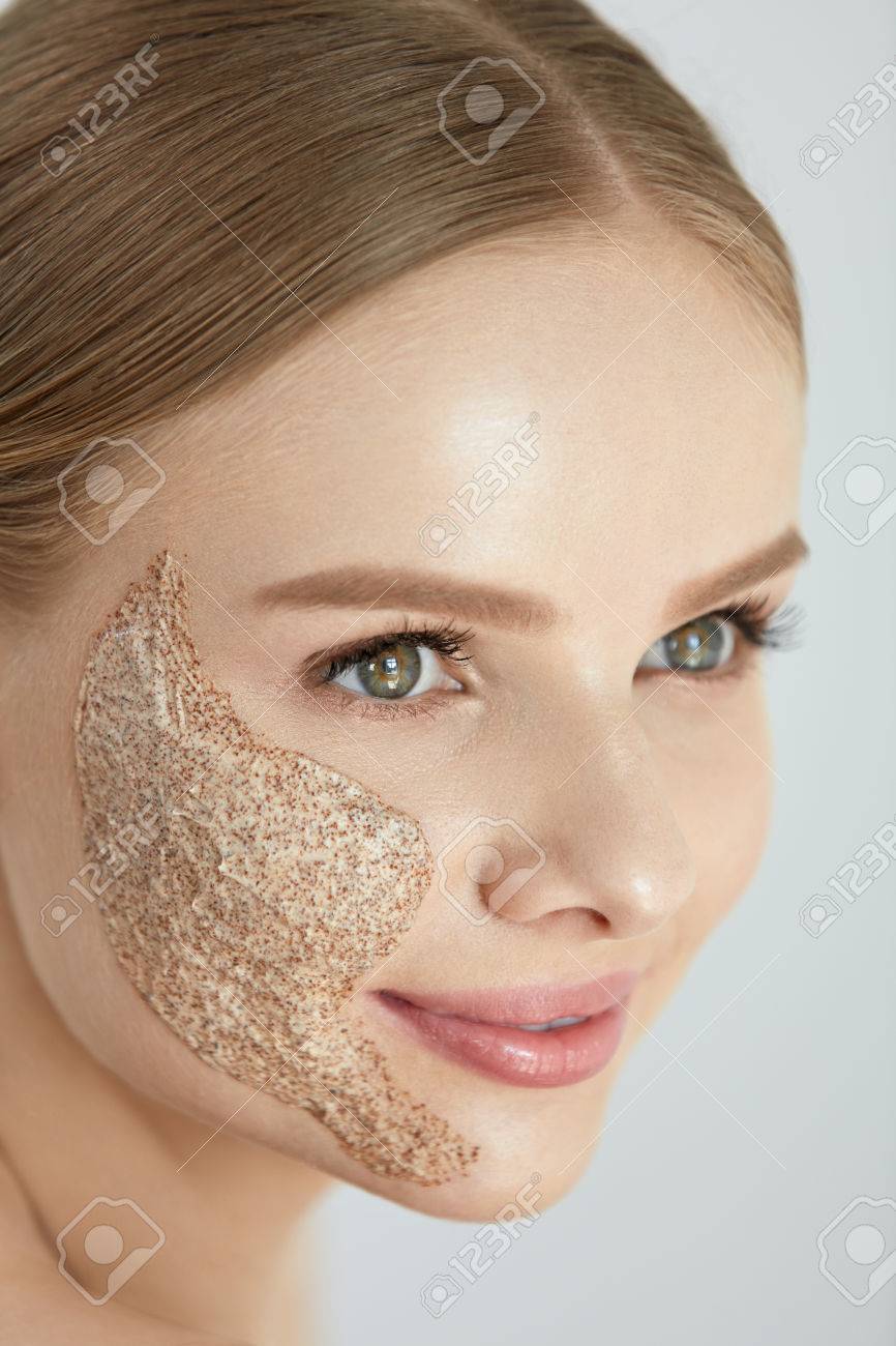 顔の皮膚のスクラブ マスクを顔の皮膚にピーリング化粧品を適用する美しい幸せな笑顔若い女の肖像画 高分解能 の写真素材 画像素材 Image