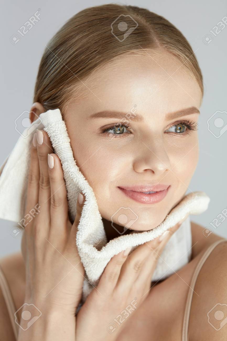 Woman Cleaning Face With White Towel. Closeup Portrait Of Beautiful Happy  Smiling Young Female Wiping Facial Skin With Soft Facial Towel After Washing  Face. High Resolution Stock Photo, Picture And Royalty Free