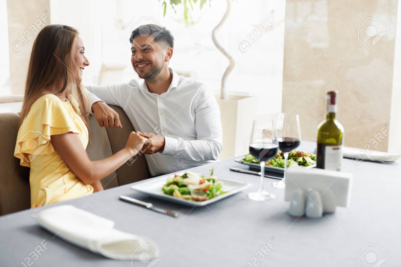 Romantic Couple Having Dinner For Two In Restaurant. Beautiful Happy People In Love Talking, Laughing, Flirting While Having Romantic Date With Wine And Food In Luxury Restaurant. High Quality Image. - 92440059 Romantic Couple Having Dinner For Two In Restaurant. Beautiful Happy People In Love Talking, Laughing, Flirting While Having Romantic Date With Wine And Food In Luxury Restaurant. High Quality Image. - 92440059