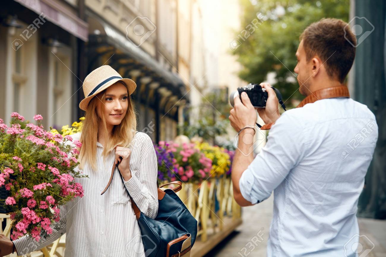 観光カップル 路上で女性の写真を撮るカメラを持つ男 スタイリッシュな服を着て旅をし 屋外で写真を撮る若いカップルを笑顔 人々は週末に旅行します 高解像度 の写真素材 画像素材 Image