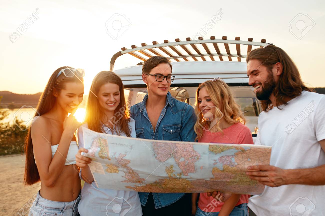 Summer Travel Friends Using Map Near Car In Nature Happy Smiling People Traveling In Bus On Weekend Vacation Beautiful Young Men And Women Holding Map Exploring Location On Trip High Quality Stock