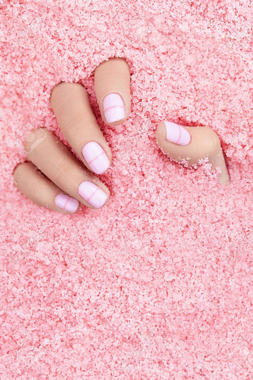 カラフルな海塩で爪を持つ女性の手 ピンクの海塩で白いマニキュアで女性の手をクローズアップ 高品質の画像 の写真素材 画像素材 Image