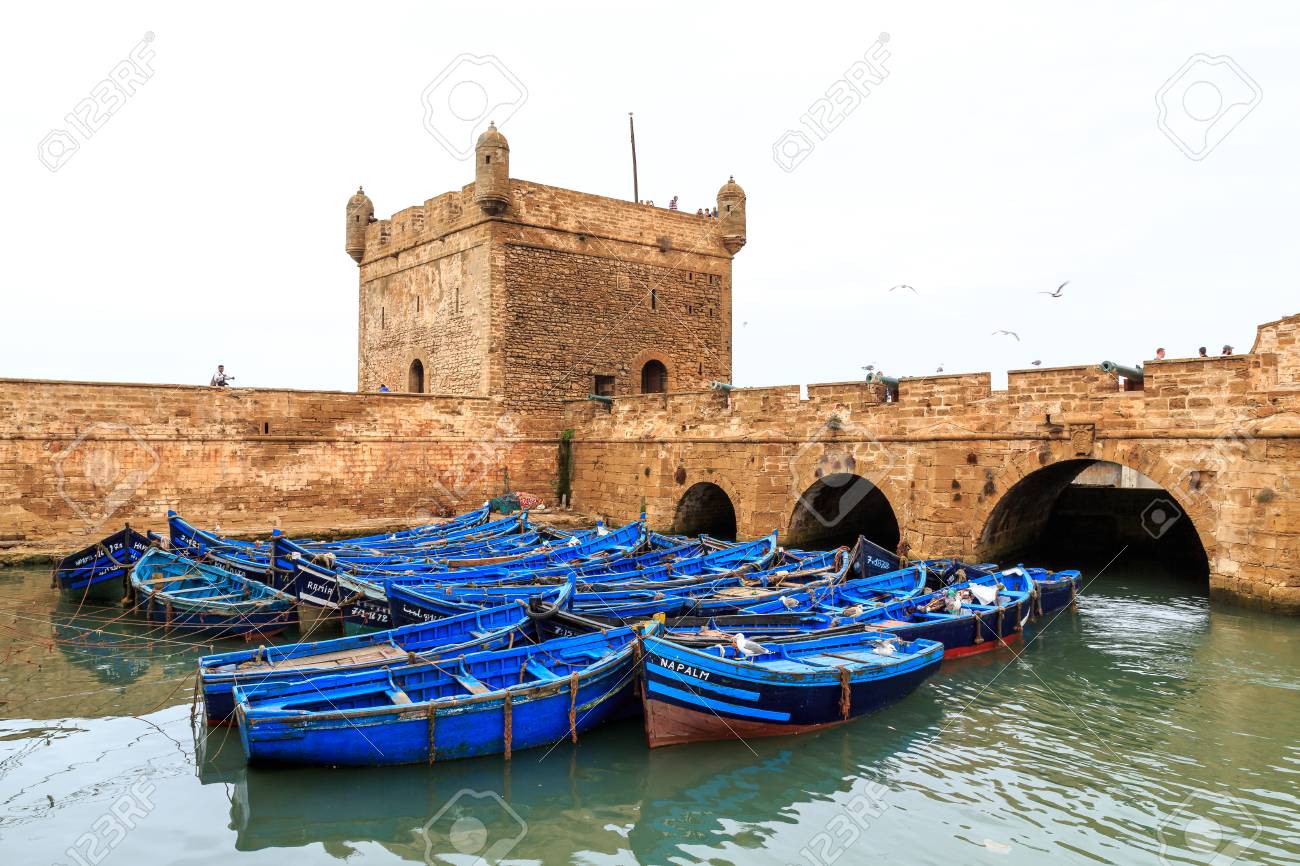 https://previews.123rf.com/images/pwollinga/pwollinga1702/pwollinga170200116/74528831-small-blue-boats-in-the-harbor-of-essaouira-morocco-with-fortress.jpg