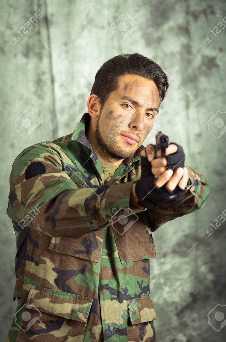 前面に銃を指して迷彩服で兵士 militar ラテン男の肖像 ロイヤリティー