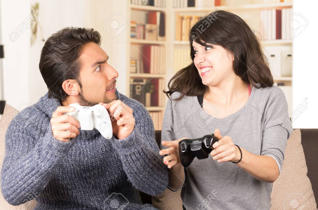Young Cute Competitive Boyfriend Girlfriend Playing Video Games In Couch Stock Photo, Picture and Royalty Free Image. Image 34313215.