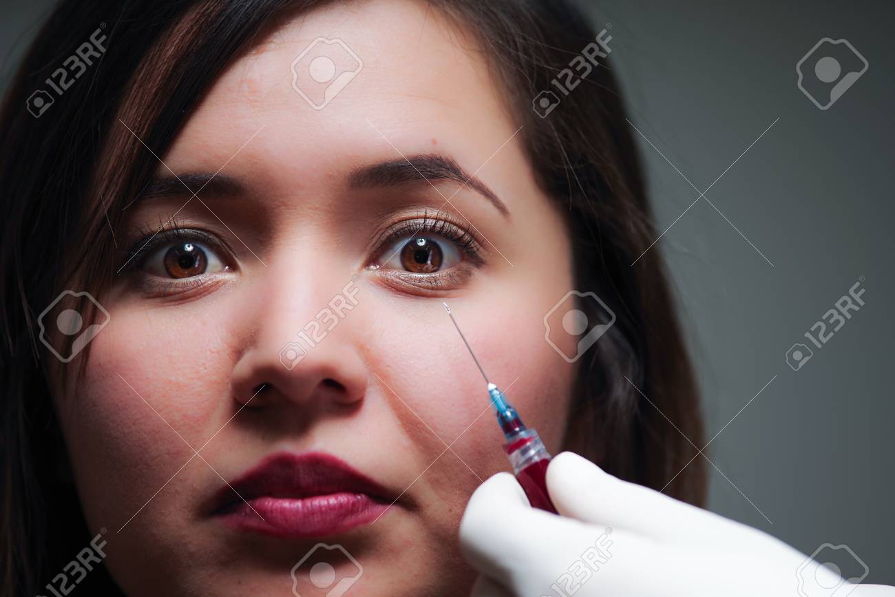 彼女の顔の近くの針の注射治療の怖いの美しい女性の肖像画 の写真素材 画像素材 Image