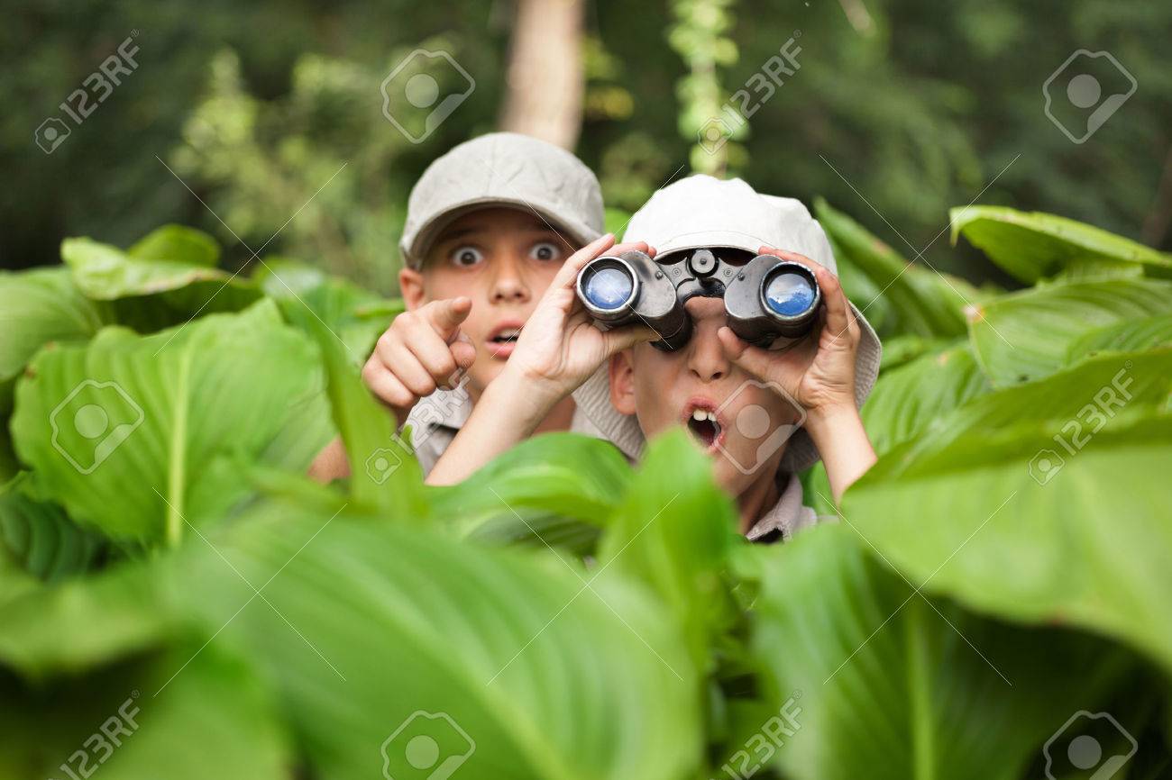 two Boy hiding in grass looking through binoculars outdoor - 62264968 two Boy hiding in grass looking through binoculars outdoor - 62264968