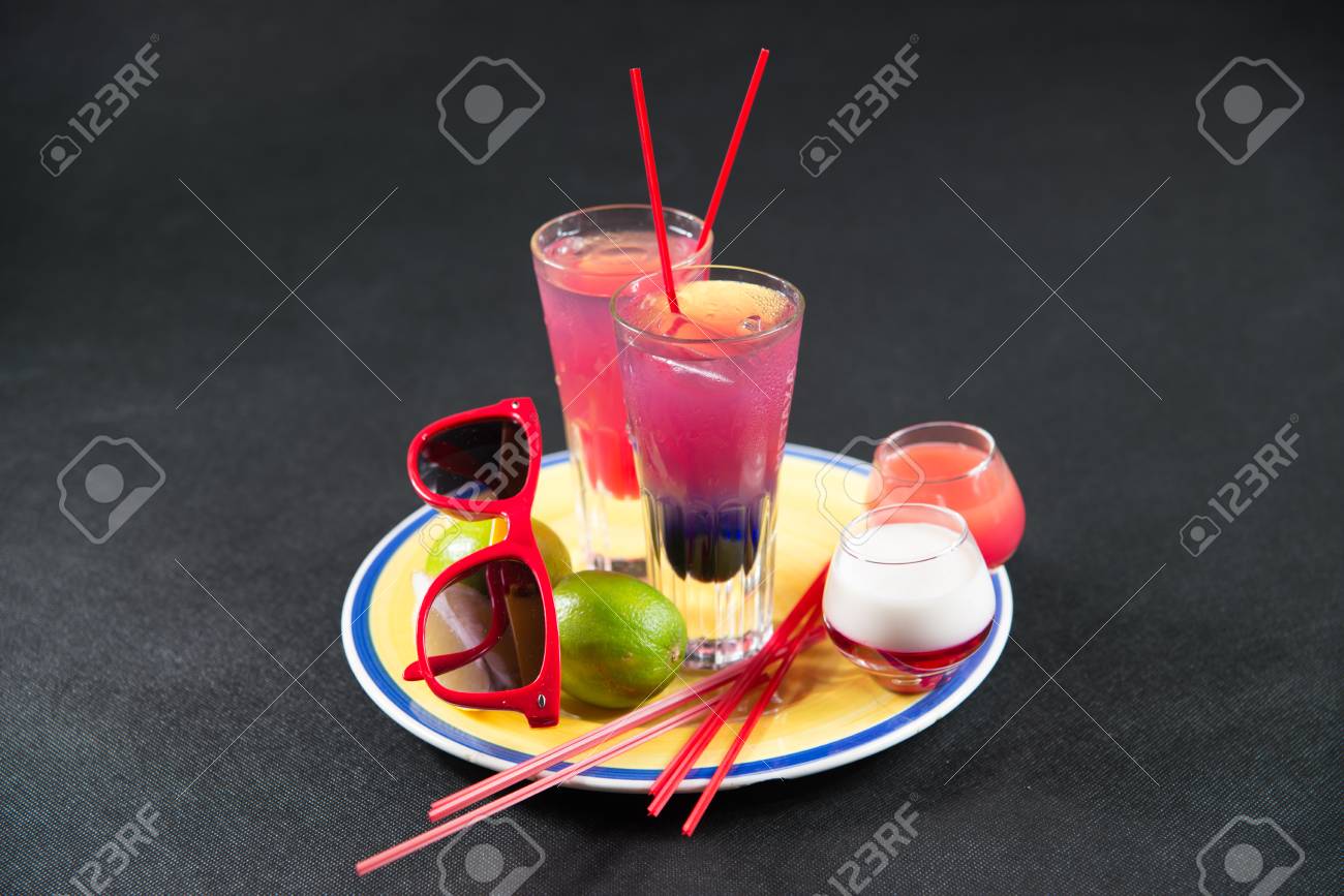 2 つの色の飲み物 紫と紺の組み合わせ 赤 ピンク ロングド リンク ガラス 別の 2 つの 2 番目の組み合わせドリンク ショット 黄色と赤のサングラス 黄色と青のプレート パーティー セット の写真素材 画像素材 Image